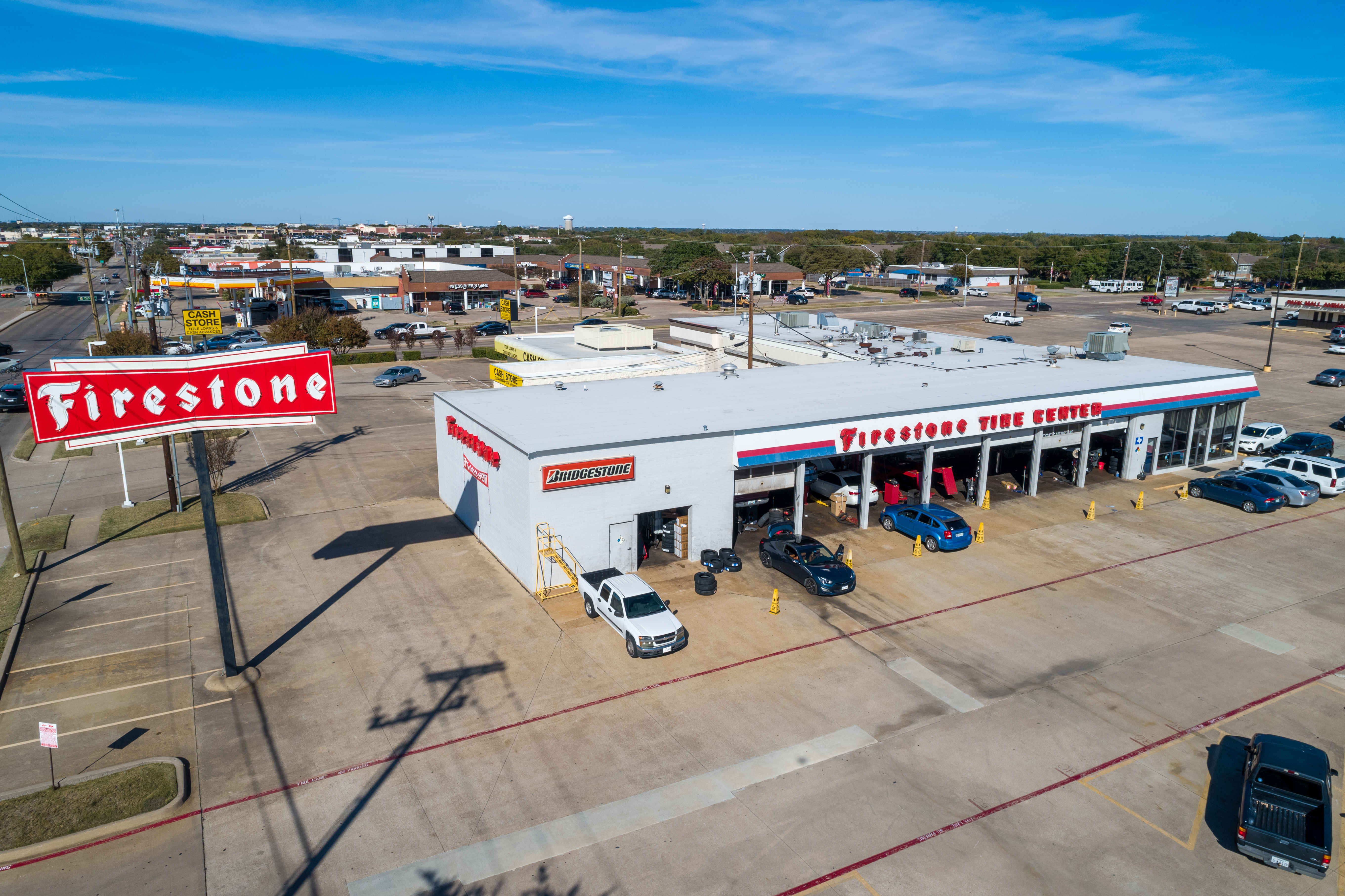 High-angle commercial drone photography of a bustling DFW retail property.